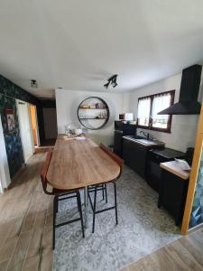 Le VaudreuilLa framboisette的厨房配有木桌和水槽。
