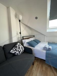 Hanwell4 Wharncliffe Drive的一间卧室配有一张床、一张沙发和一个窗口