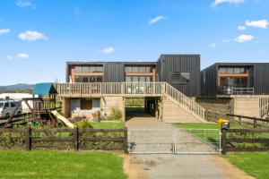 Otaki BeachBeachside Sanctuary - Otaki Beach Holiday Home的前面有围栏的房子