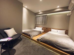 福冈TABISAI HOTEL Grande 博多的一间设有两张床和椅子的房间