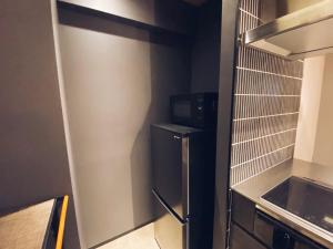 福冈TABISAI HOTEL Grande 博多的小厨房配有冰箱和微波炉。