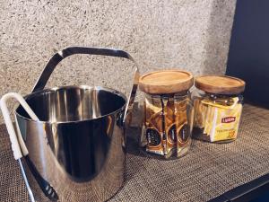 福冈TABISAI HOTEL Grande 博多的桌子上一桶和两罐蜂蜜