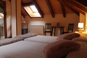 伊萨瓦Casa Rural Anie的一间卧室配有两张床和一张桌椅