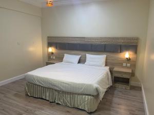 Ash Shishahفندق نزهة النسيم的卧室配有一张带两个枕头的大白色床