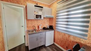 马夫拉Family Surf Home - Bungalows的一间带水槽和微波炉的小厨房