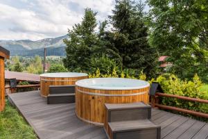 考斯赛力克Tatra Resort & SPA的甲板上的按摩浴缸,设有2个长椅