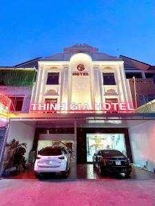 Bến CátThinh Gia Hotel的前面有两辆车的酒店