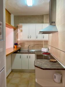 伊斯费古耶拉尔海滩费雷尔公寓酒店的厨房配有白色橱柜和水槽
