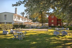 斯德哥尔摩哈根别墅酒店的一个带桌椅的庭院和一个红色谷仓