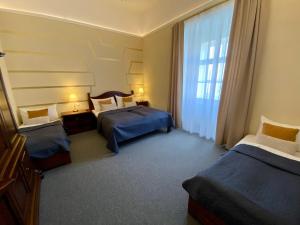 瓦尔季采Zámecký Hotel ANTON FLORIAN的酒店客房设有两张床和窗户。