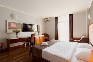 巴统Hotel 19 Batumi的配有一张床和一张书桌的酒店客房