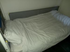 卢顿Byron View House的小房间配有一张带白色床单的床
