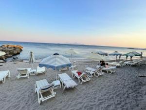 卡尔扎迈纳Efi studios的海滩上的一组椅子和遮阳伞