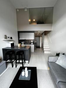 万塔Cozy Penthouse Loft - Near The Airport的客厅以及带沙发和桌子的厨房。