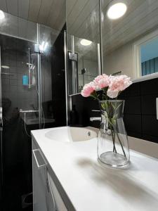 万塔Cozy Penthouse Loft - Near The Airport的浴室内一个花瓶,上面有粉红色的花朵