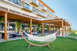 卡巴纳斯·德·塔维拉AP Cabanas Beach & Nature - Adults Friendly的酒店前草坪上的吊床