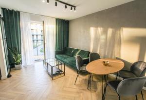 济夫努夫Nadmorskie Apartamenty - apartament SPA Dziwnów的客厅配有绿色沙发和桌子