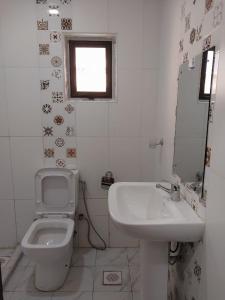 内罗毕Nairobi Glory Palace Hotel Ltd的白色的浴室设有卫生间和水槽。
