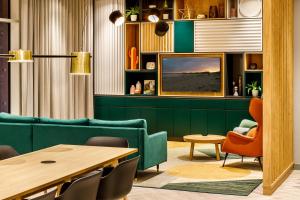霍尔Holiday Inn Manchester Airport, an IHG Hotel的客厅配有绿色沙发和桌子