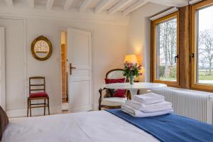 Biéville-en-AugeMaison "Le Pressoir" avec Grand Jardin的一间卧室配有一张床、一张桌子和毛巾