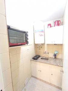 门多萨Departamento Temporario Céntrico Mendoza的一间带水槽和微波炉的小厨房