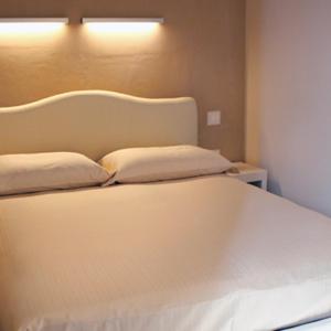 SerrungarinaAgriturismo Pozzuolo的一张白色的床,上面有两个枕头
