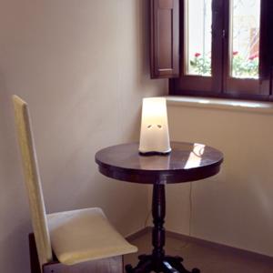 SerrungarinaAgriturismo Pozzuolo的一张小桌子,放在一个椅子和窗户的房间