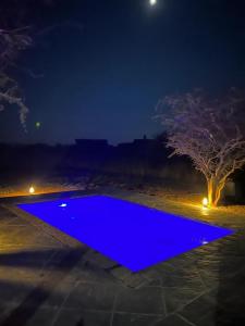 马布拉Luna Piena 19A Zebula golf course and spa resort的夜晚的蓝色游泳池,有树
