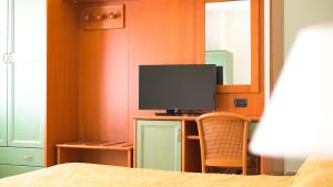 科里利亚诺·卡拉布罗Apulia Hotel Corigliano Calabro的一间卧室,配有桌椅和一台电视