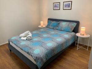 奥克利Chadstone Holiday E2 Villa的一间卧室配有一张带两张桌子和两盏灯的床。