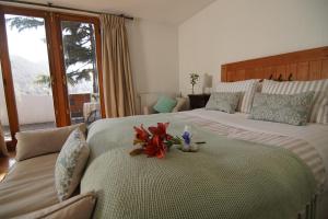 圣地亚哥Casa Arrayán的酒店客房的床上摆放着两张鲜花