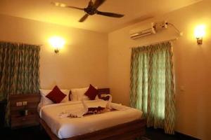 德瓦纳哈利-班加罗尔ZIONS HOTEL AND APERTMENT的一间卧室配有一张床和吊扇