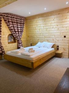 AradaCăsuța din Povești的卧室配有一张木墙内的大床