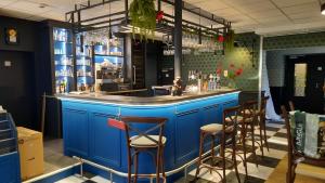 Nieul-sur-lʼAutiseL'Auberge des Artistes的餐厅的蓝色酒吧,带凳子