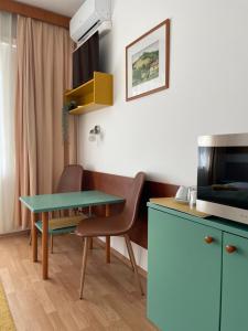 蒂豪尼Hello Balcsi Apartmanház的客房设有书桌、桌子和电视。