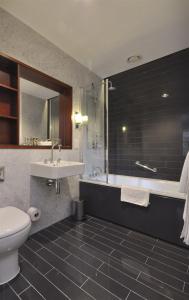 剑桥Downing College的浴室配有卫生间、盥洗盆和浴缸。