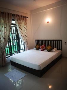锡吉里亚Hotel Bird Paradise的一张位于带大窗户的房间内的床铺