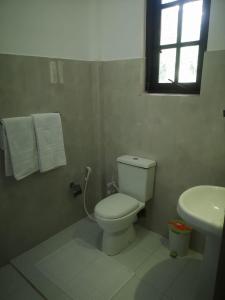 锡吉里亚Hotel Bird Paradise的白色的浴室设有卫生间和水槽。