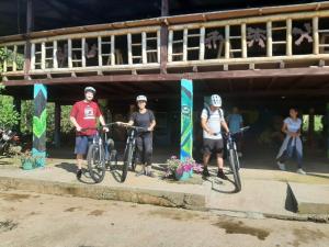 比利亚加松Donde se Oculta el Sol的三个人站在一座建筑前面,骑着自行车