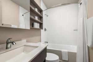 Sainte-Thérèse-de-BlainvilleMicrotel Inn & Suites by Wyndham Boisbriand的浴室配有盥洗盆、卫生间和浴缸。