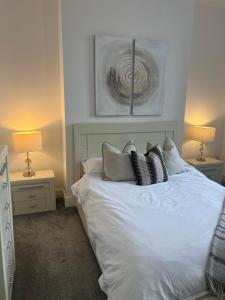 普里茅斯97a 97b Captains House的卧室配有带枕头和两盏灯的白色床。