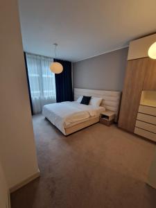 布加勒斯特Anvers Apartament的卧室设有白色的床和大窗户