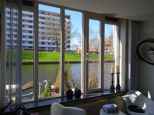 阿姆斯特丹阿姆斯特丹西部住宿加早餐酒店的客房设有3扇窗户,享有河景