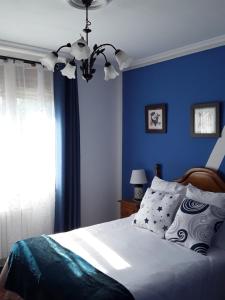 桑提亚纳德玛Casa Rural Mariluz的蓝色的卧室,配有床和蓝色的墙壁