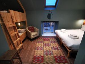 克里夫Comrie Croft的一间设有两张床、椅子和地毯的房间