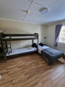 Raufoss贝德酒店的铺有木地板的客房内设有两张双层床。