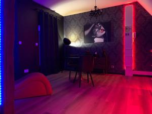 BonnétableLove room avec jacuzzi privé的一间设有一张桌子的红色灯室