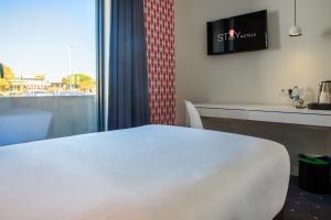 里斯本Stay Hotel Lisboa Aeroporto的酒店客房设有白色的床和窗户。