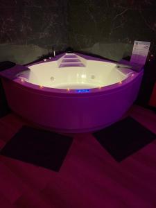 BonnétableLove room avec jacuzzi privé的客房内的紫色浴缸