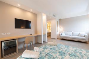 奥尔比亚Molo Brin Rooms & Suites的客厅配有沙发和墙上的电视